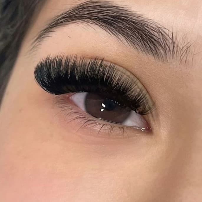 L'oeil d'une femme avec un volumme méga russe pour ses sourcils.