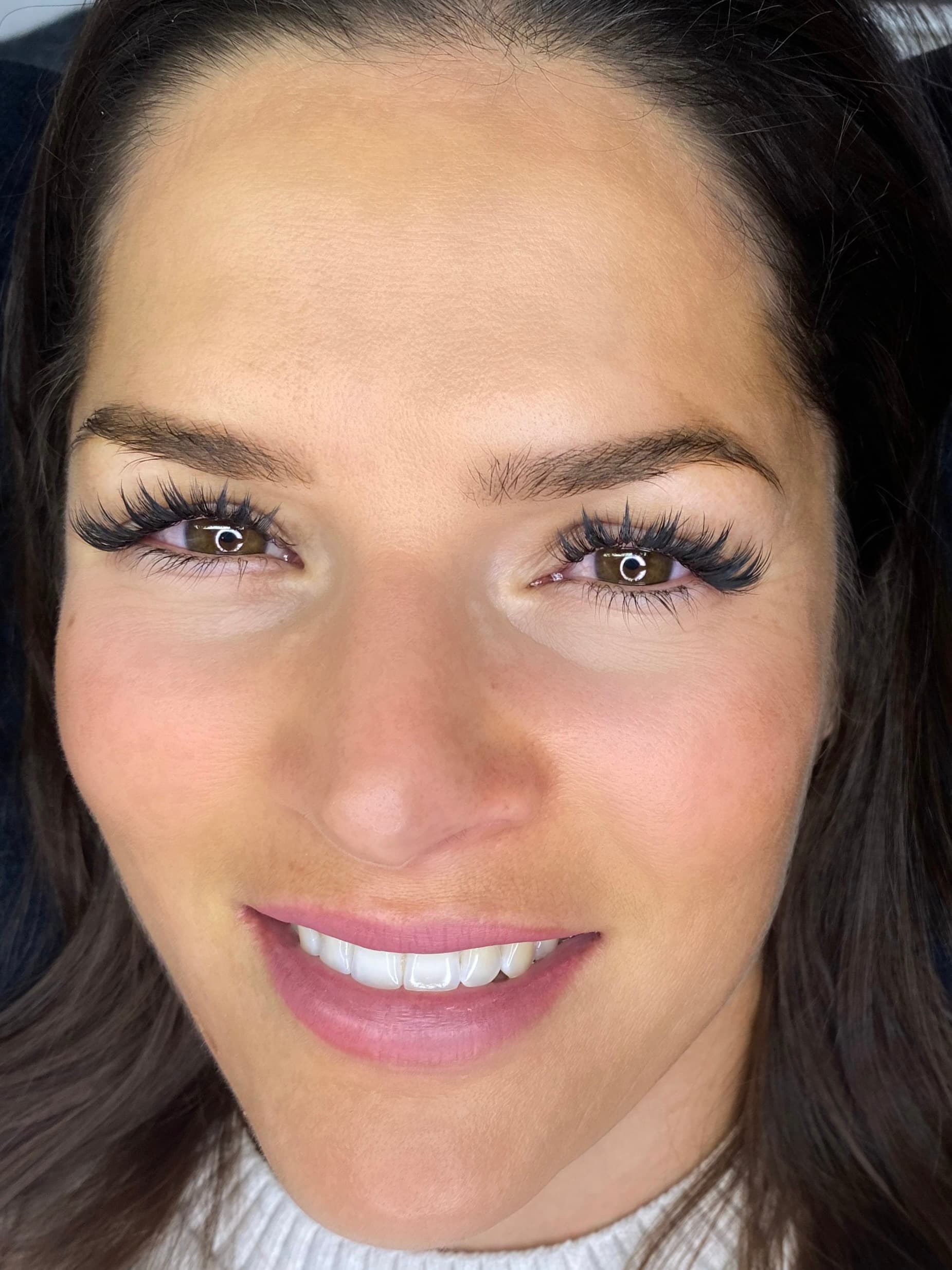 A dense, drawn lash line after a Russian volume set done by the trainer, with no makeup